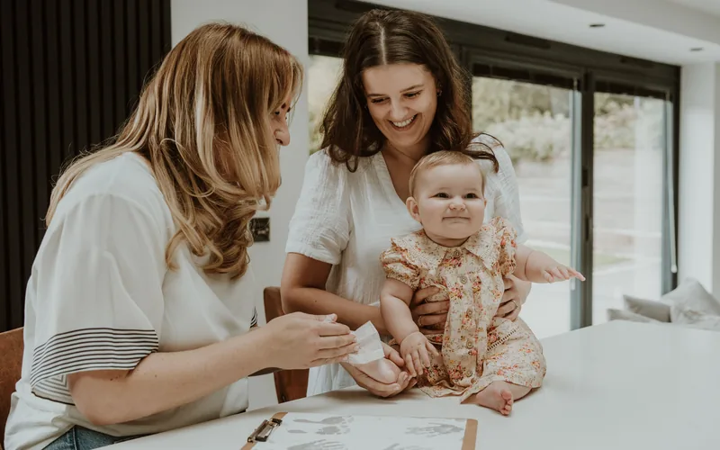 A Memory Catcher taking a baby's prints while mum holds her