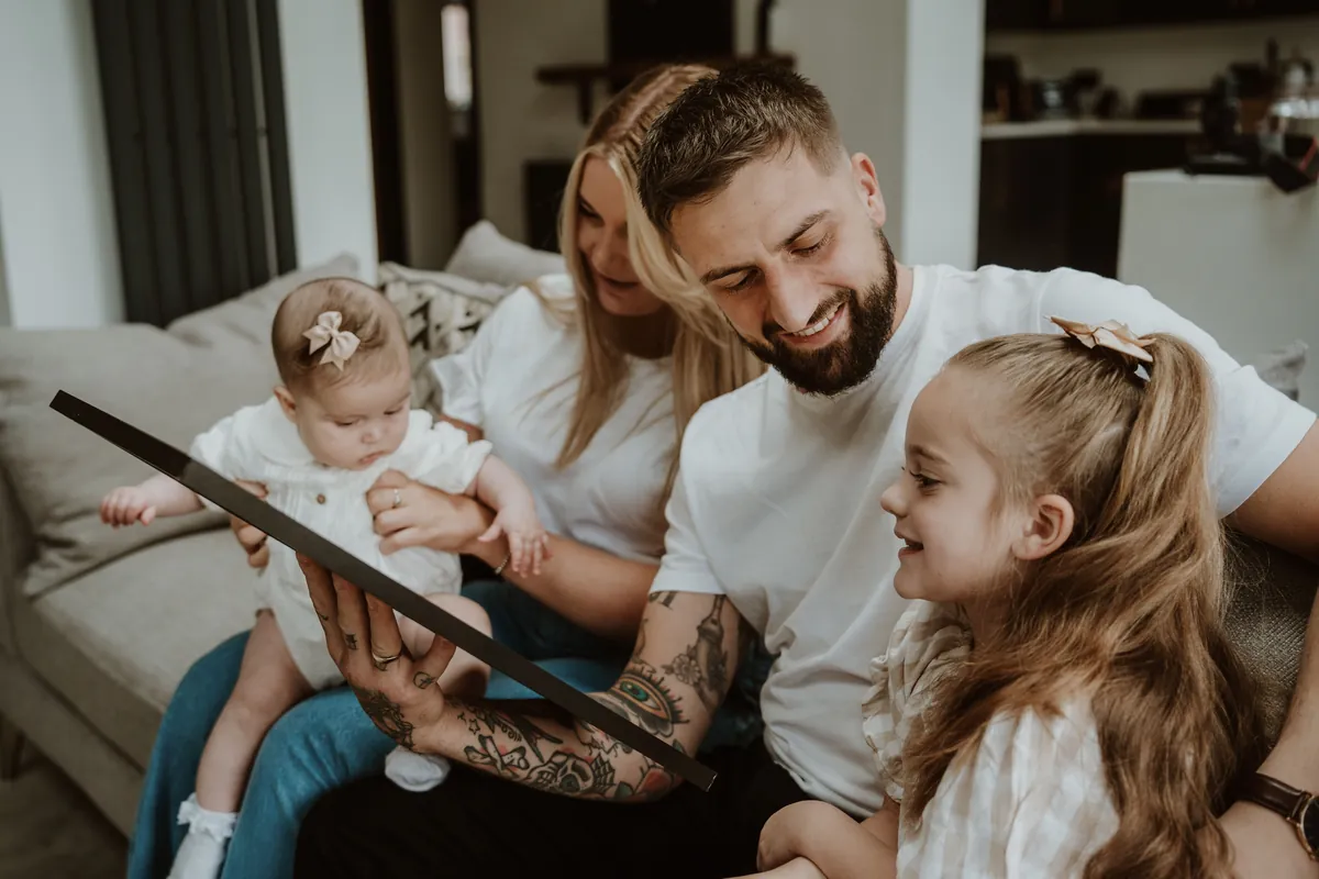 A family looking together at their baby's framed foil print
