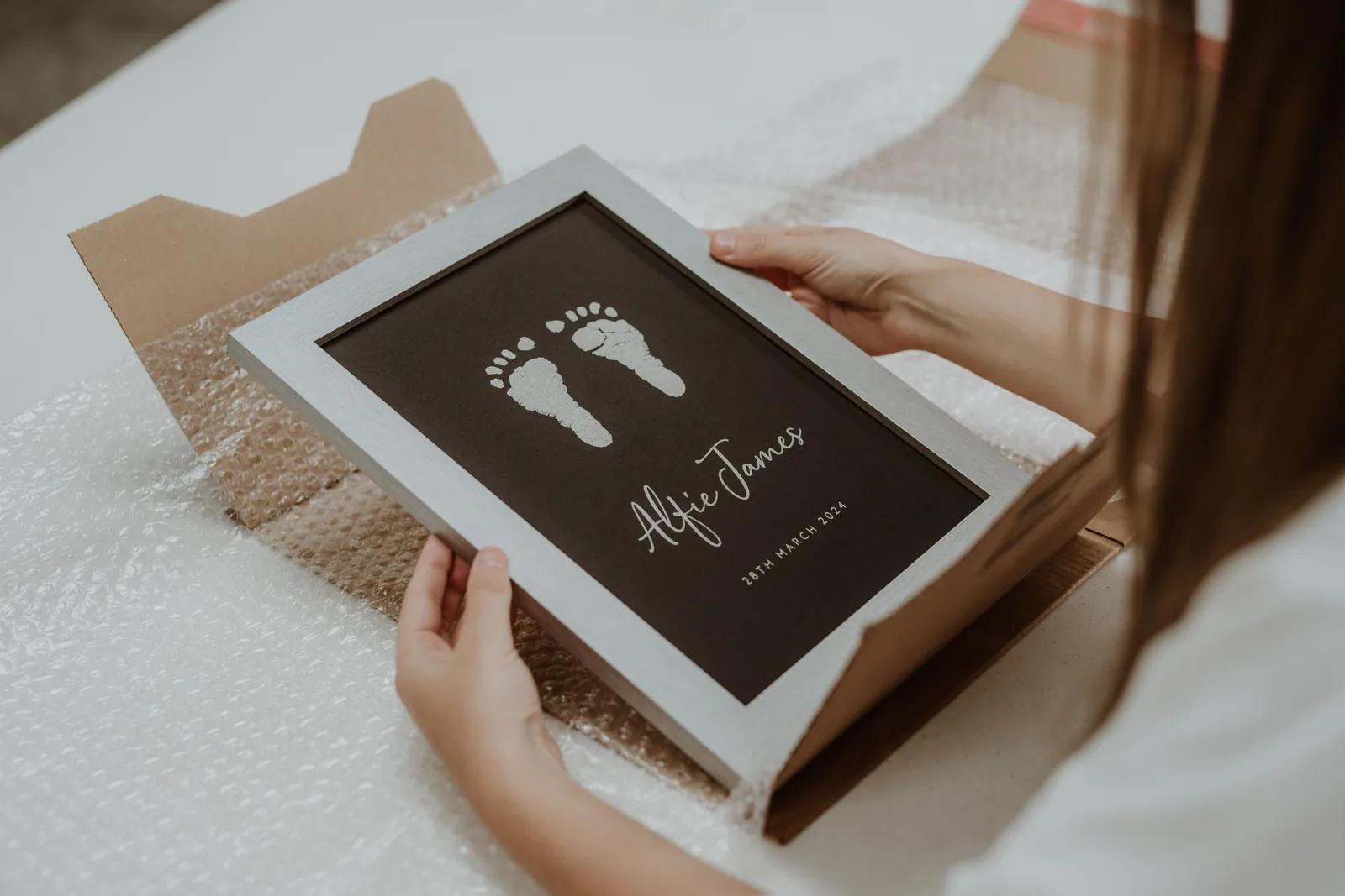A framed keepsake held in both hands